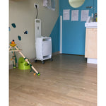 Children's bathroom with toilet training equipment, sink, and blue wall.