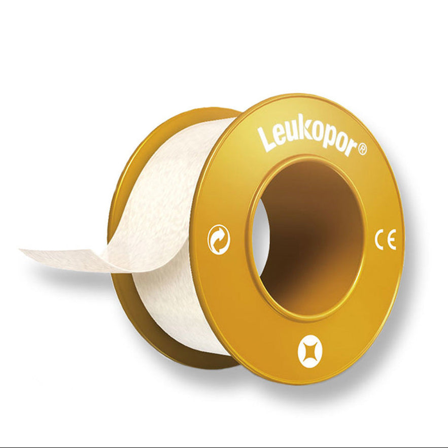 Gold spool of Leukopor tape on a white background
